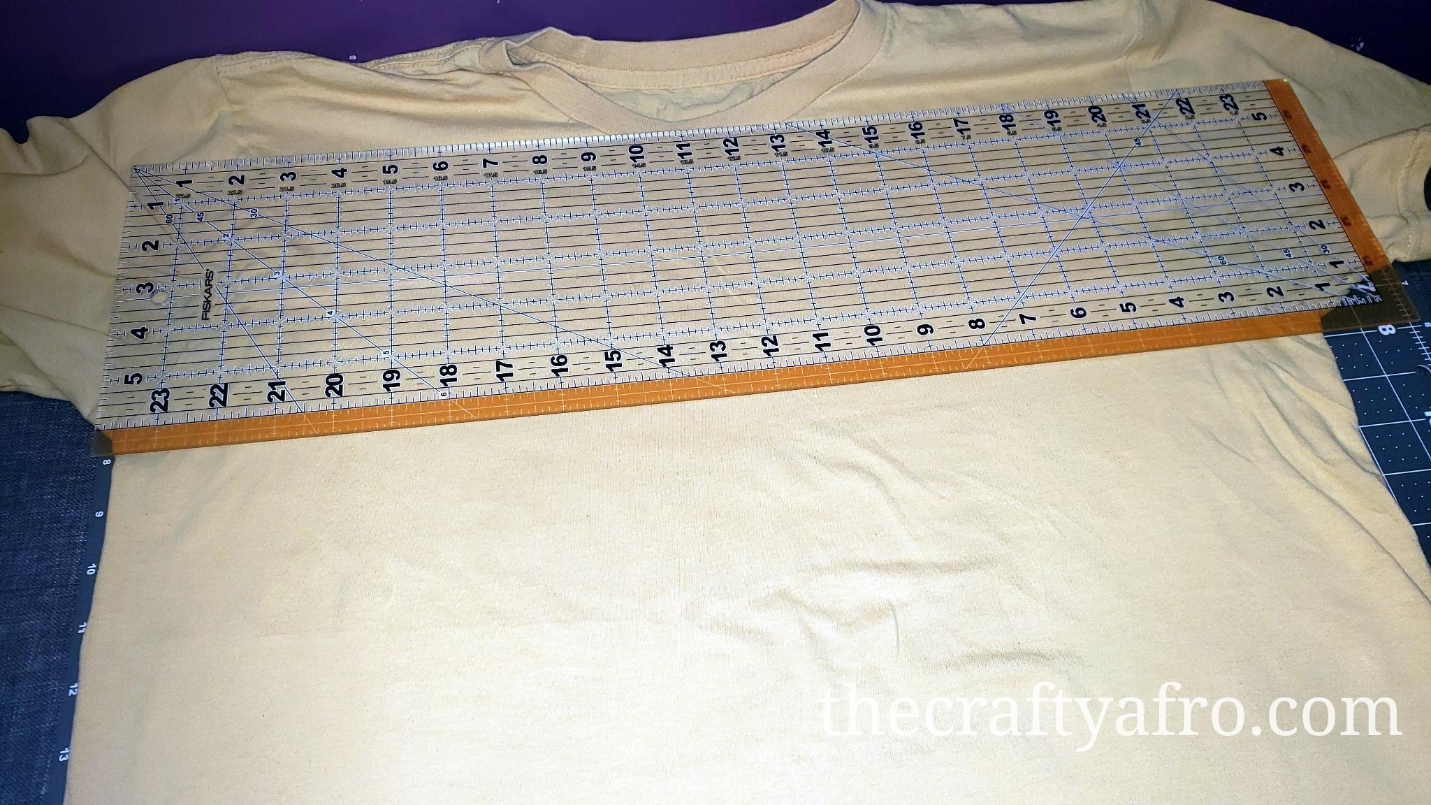 Clear ruler placed underneath the arms of a t-shirt.